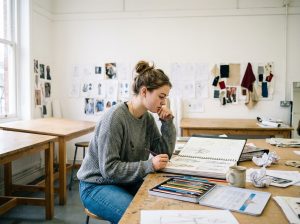 Jeune étudiante en dessin dans un atelier lumineux